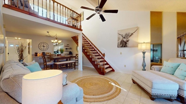 tiled living room featuring ceiling fan with notable chandelier and high vaulted ceiling