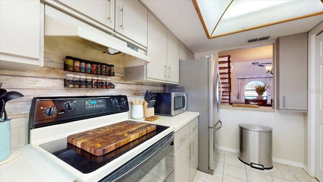 kitchen with white cabinetry, ceiling fan, light tile patterned flooring, and stainless steel appliances