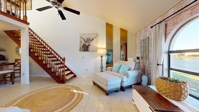 tiled living room featuring a textured ceiling, high vaulted ceiling, and ceiling fan