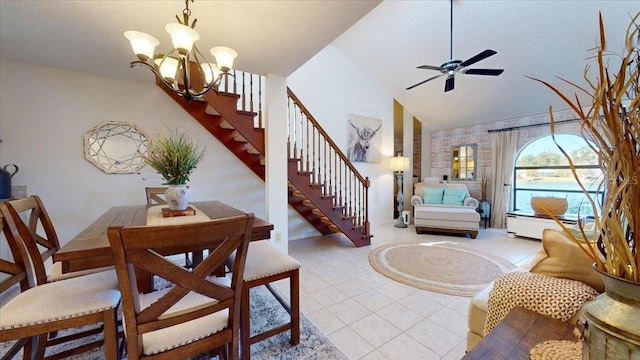 tiled dining room with ceiling fan with notable chandelier and lofted ceiling