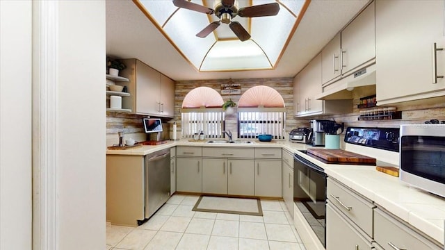 kitchen with sink, white electric stove, stainless steel dishwasher, tile counters, and light tile patterned flooring