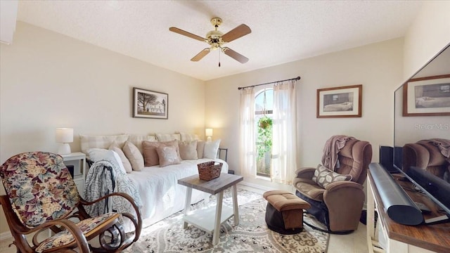 living room featuring a textured ceiling and ceiling fan