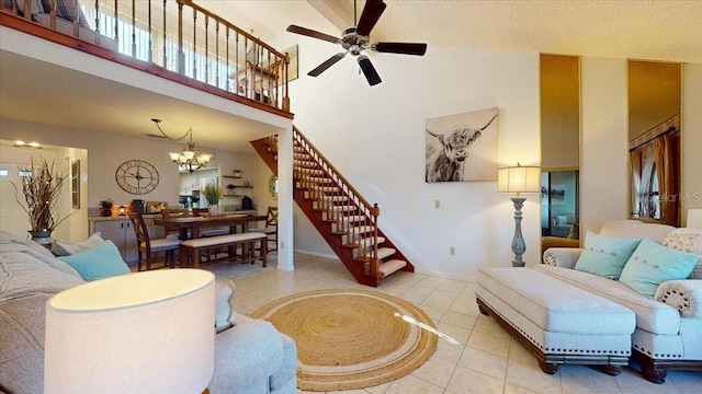 tiled living room with high vaulted ceiling and ceiling fan with notable chandelier