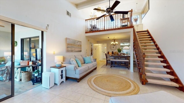 living room with tile patterned flooring, a high ceiling, and ceiling fan with notable chandelier