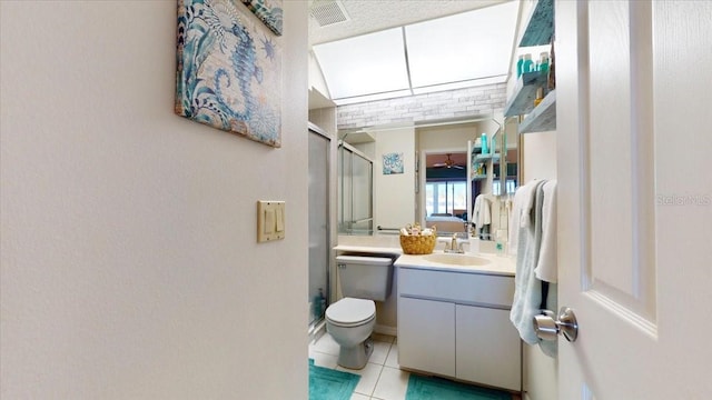 bathroom with tile patterned flooring, vanity, toilet, and walk in shower