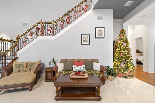 living room with light tile patterned flooring and a high ceiling