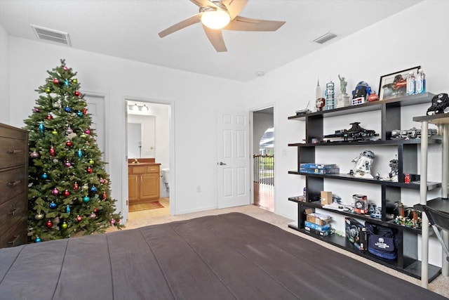 bedroom with ensuite bath, ceiling fan, and light colored carpet