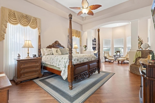 bedroom featuring decorative columns, ceiling fan, and hardwood / wood-style floors