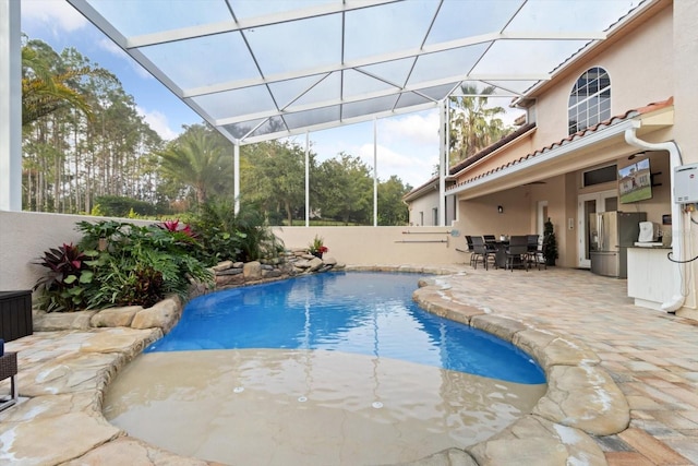 view of swimming pool featuring a patio and a lanai