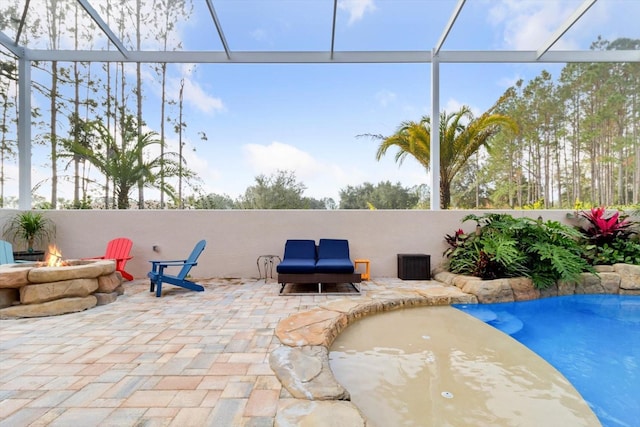 view of swimming pool with a lanai, a patio area, and a fire pit