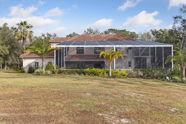 back of house with a yard and glass enclosure