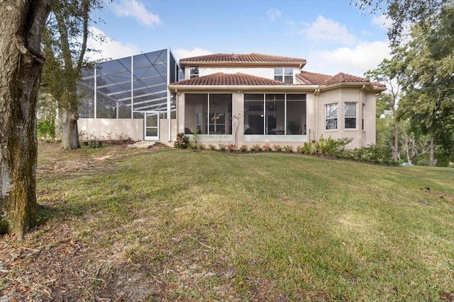 rear view of house featuring glass enclosure and a yard