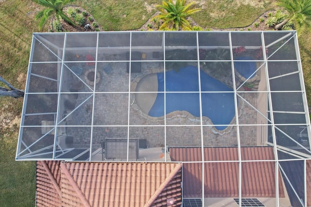 view of property exterior with glass enclosure and a patio area