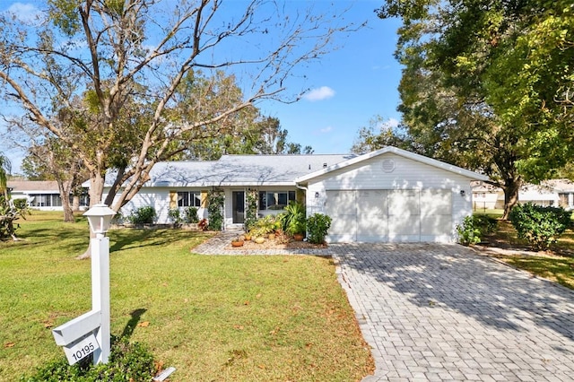 ranch-style home featuring a garage and a front lawn