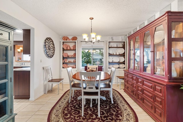 tiled dining space with a chandelier and a textured ceiling