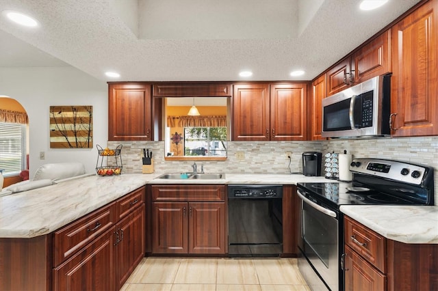 kitchen with kitchen peninsula, appliances with stainless steel finishes, decorative backsplash, and sink