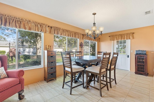 dining area with light tile patterned floors and a chandelier