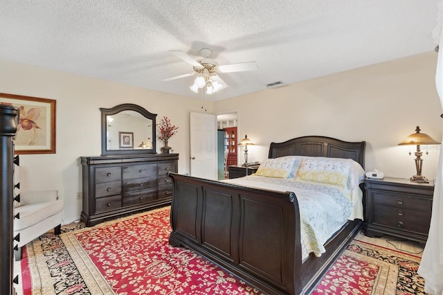 bedroom featuring ceiling fan and a textured ceiling