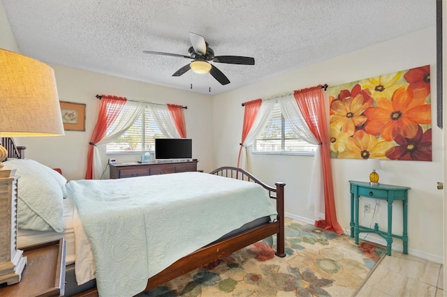 bedroom with ceiling fan and a textured ceiling