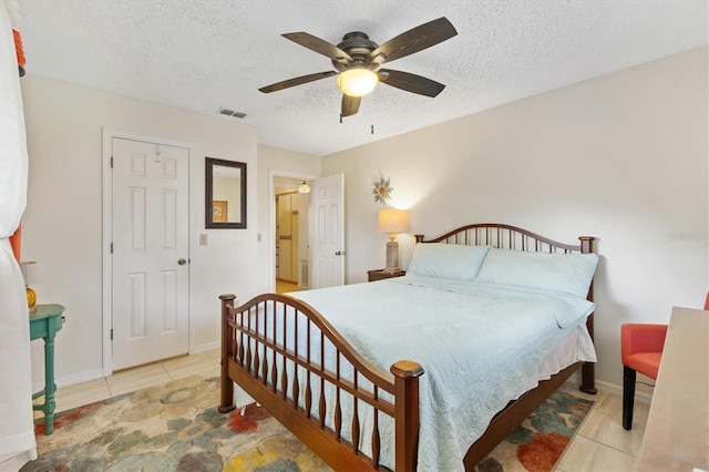 tiled bedroom featuring ceiling fan and a textured ceiling