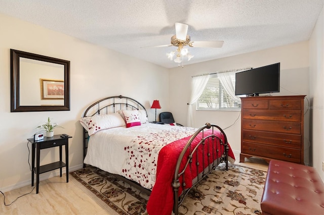 bedroom with ceiling fan and a textured ceiling