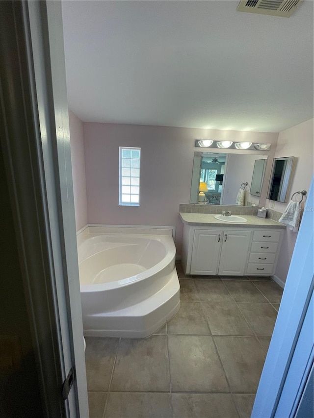 bathroom with a tub, tile patterned flooring, and vanity