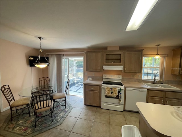 kitchen featuring light tile patterned flooring, pendant lighting, white appliances, and sink