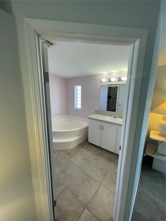 bathroom featuring vanity, tile patterned floors, and a tub