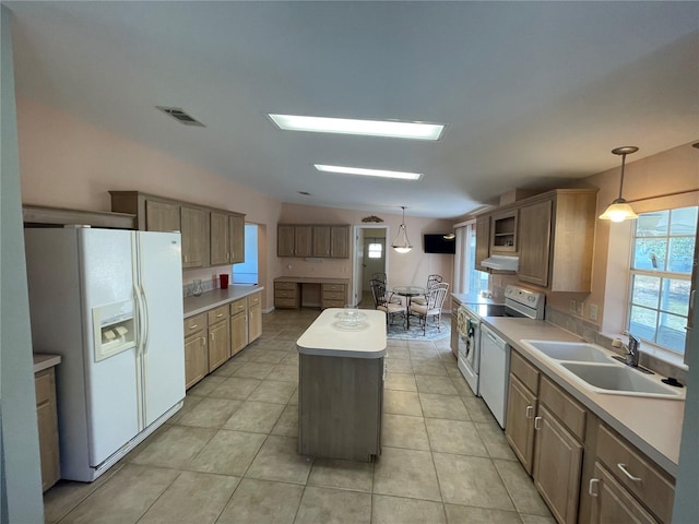 kitchen with sink, a kitchen island, pendant lighting, and white appliances