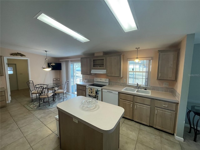 kitchen with sink, a kitchen island, a healthy amount of sunlight, and white appliances