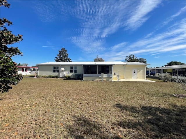 rear view of house featuring a lawn and a patio