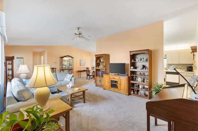 living room with ceiling fan, light colored carpet, and vaulted ceiling