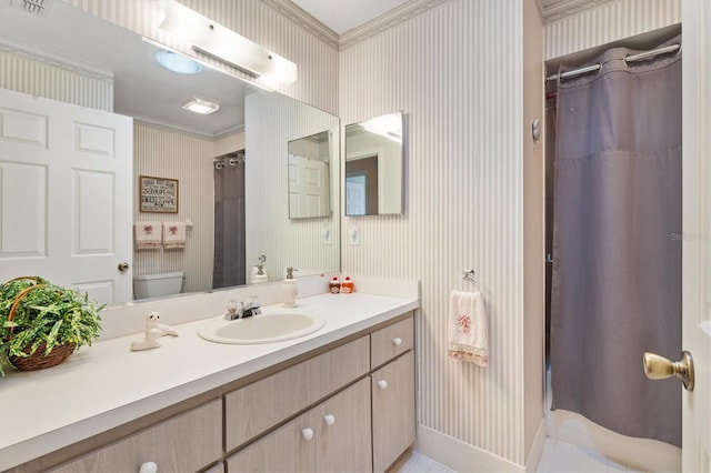 bathroom with vanity, toilet, and crown molding