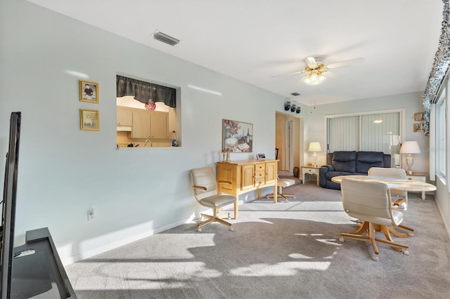 carpeted living room with ceiling fan