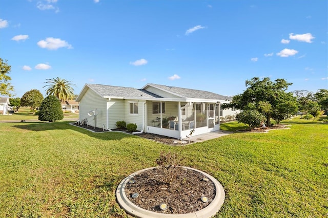 back of property with a sunroom and a lawn