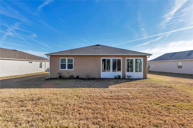 rear view of property featuring a lawn