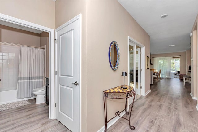 corridor with light hardwood / wood-style floors