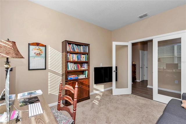 home office with light colored carpet and french doors