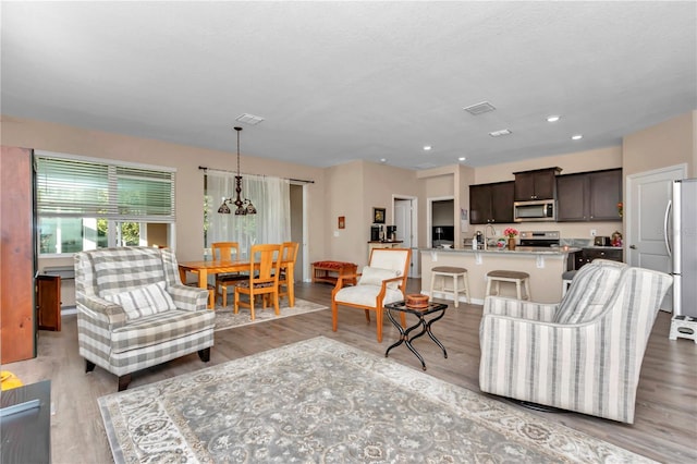 living room with sink, light hardwood / wood-style flooring, and a textured ceiling