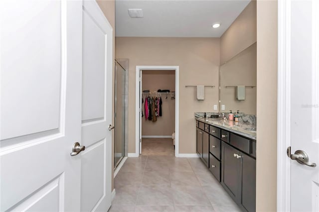 bathroom with tile patterned floors, a shower with shower door, and vanity