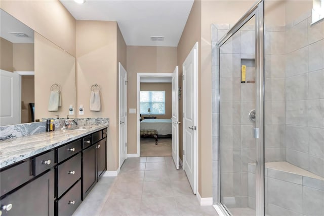 bathroom featuring vanity, a shower with shower door, and tile patterned flooring