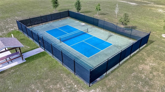 view of tennis court featuring a lawn