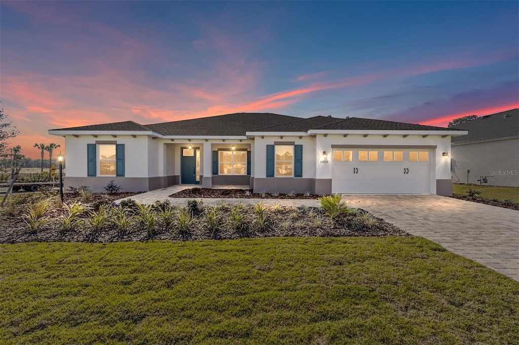 view of front of home featuring a garage and a lawn