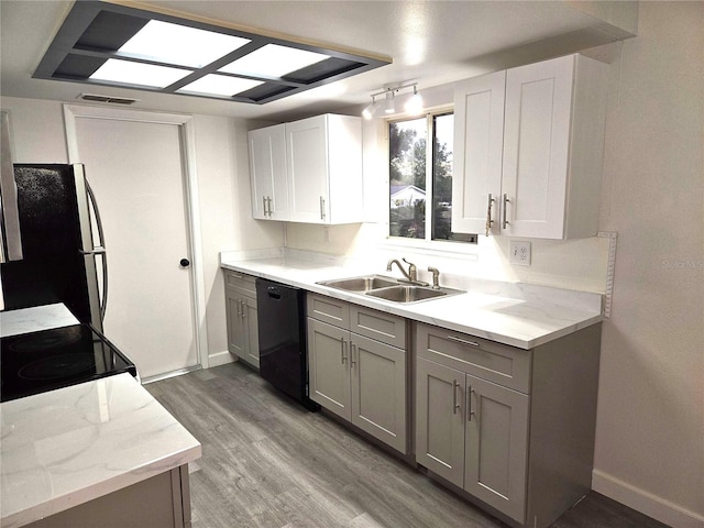 kitchen featuring gray cabinetry, sink, black appliances, and light wood-type flooring