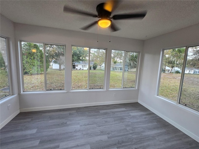 unfurnished sunroom with ceiling fan and a healthy amount of sunlight