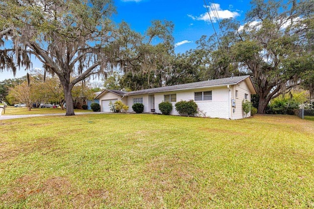 ranch-style home with a garage and a front lawn