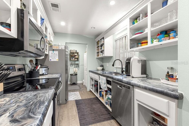 kitchen with stone counters, sink, appliances with stainless steel finishes, light hardwood / wood-style floors, and white cabinetry