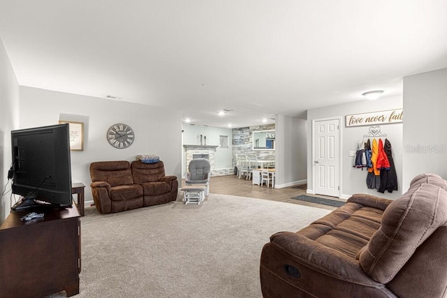 living room with light carpet and a fireplace