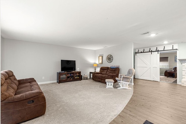 living room with hardwood / wood-style flooring and a barn door