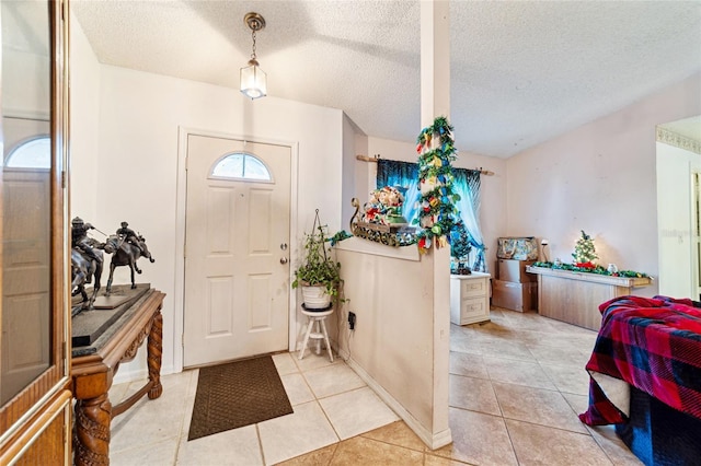 foyer entrance featuring light tile patterned floors and a textured ceiling